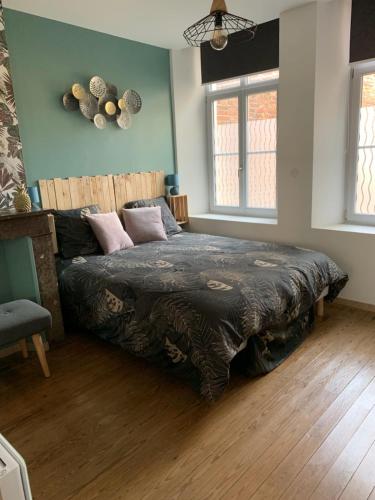 a bedroom with a large bed in a room at Le clocher d Ardres in Ardres