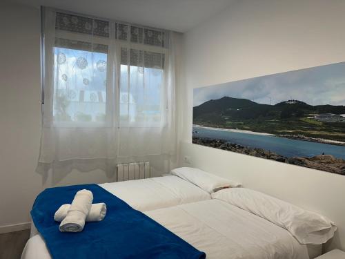 a bedroom with a bed with two towels on it at GRUPOELE3 MUXIA PUERTO in Muxia