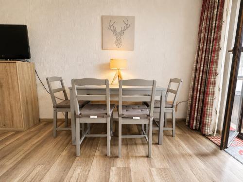 a dining room table with chairs and a lamp at Ferienwohnung Darosa Alpenliebe in Seeg