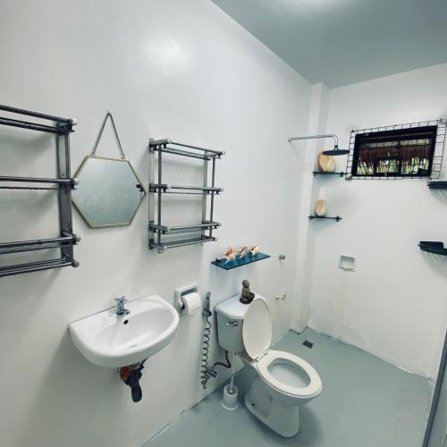 a bathroom with a toilet and a sink at Duck & Drift - a Sleeper Hostel - Just 1,7km from Airport in Puerto Princesa City