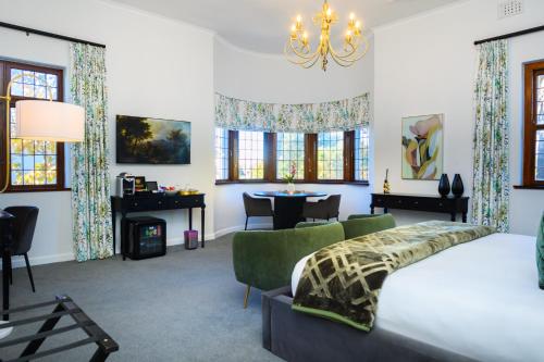 a bedroom with a bed and a desk and a table at Palm House Boutique Hotel and Spa in Cape Town