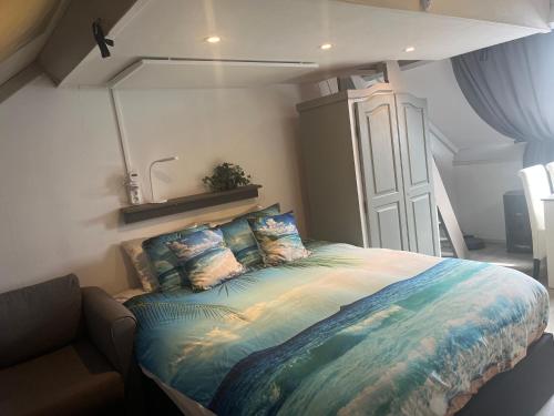 a bedroom with a large bed with pillows on it at Studio vlak bij het strand in Petten