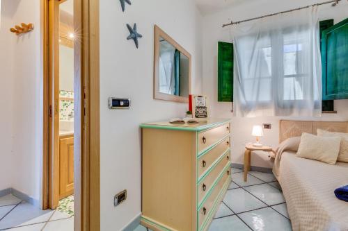 a small bedroom with a dresser and a bed at Blue Horizon Stintino in Stintino