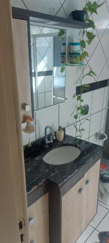 a bathroom with a sink and a mirror at Casa Nascer do Sol in Sangão