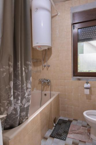 a bathroom with a tub and a toilet and a sink at Apartment Bojke in Niš