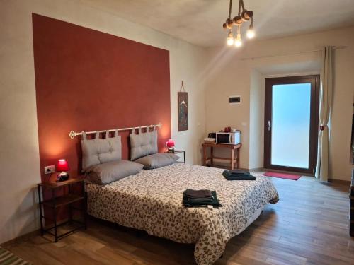 a bedroom with a large bed and a large window at Ca' della Civetta in Gavedo