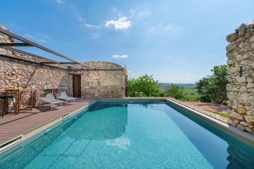 a swimming pool in front of a stone house at Agriturismo Monte Bisson - Piscina Privata in Soave