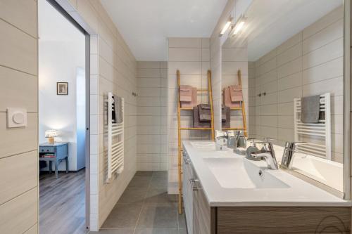 a bathroom with two sinks and a large mirror at Chambres D'hôtes Les Carmes in La Flocellière