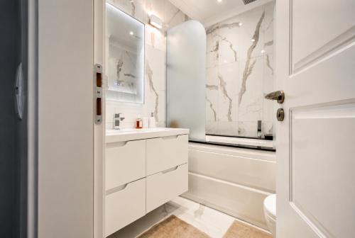 a white bathroom with a sink and a tub at Top 10 3BR2BH Jacuzzi Free Parking in Sofia