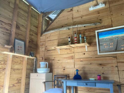 a room with a wooden wall with a table at Dortoir en charente in Jarnac