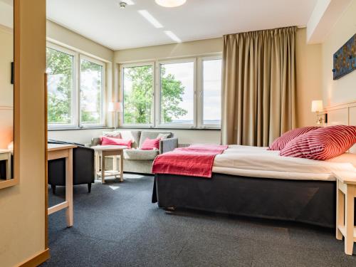 a bedroom with a bed and a desk in a room at Ringsjöstrand Camping, Hotell och Stugby in Hörby