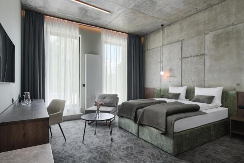 a bedroom with a large bed and a table at Hotel Zator in Zator