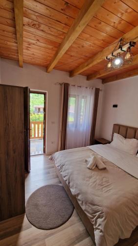 a bedroom with a large bed with a wooden ceiling at Guest House in Theth Agostini in Theth
