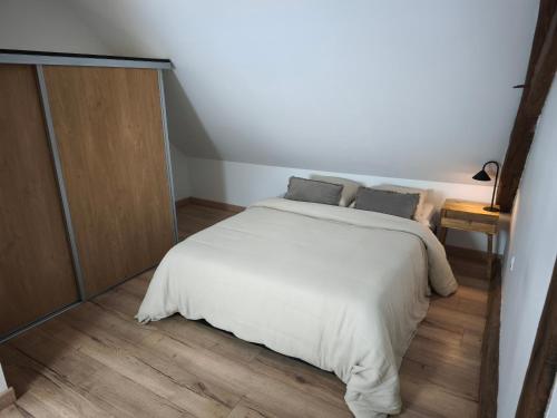 a bedroom with a white bed and a wooden floor at La Maisonnette Montlouisienne in Montlouis-sur-Loire