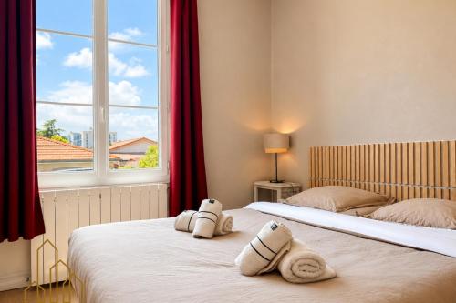 two twin beds in a room with a window at L'Esprit Descartes in Roanne