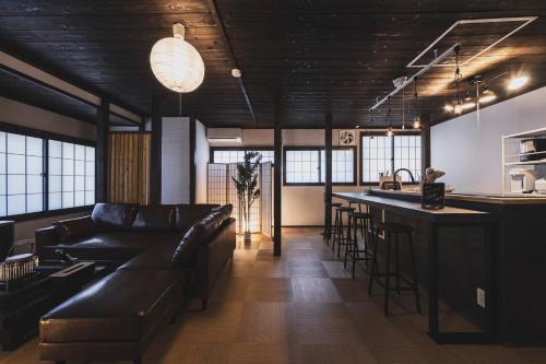 a living room with a couch and a bar at Hidasumika Ojin AN in Takayama