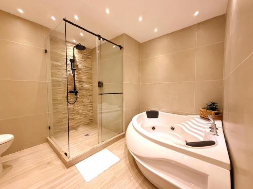 a bathroom with a tub and a shower and a toilet at Hotel Quinta de Cabecera in Bucaramanga