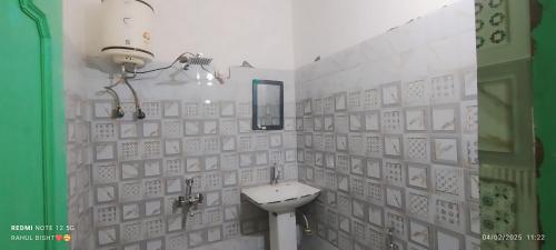 a white bathroom with a sink and a mirror at Swayambhu Hotel in Rudraprayāg