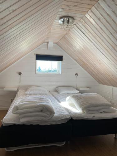 a bed in a room with a wooden ceiling at Brygghuset between Hjo and Tidaholm in Hjo