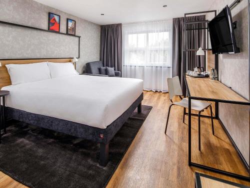 a hotel room with a large bed and a desk at IBIS Wakefield East-Castleford, M62 J31 in Wakefield