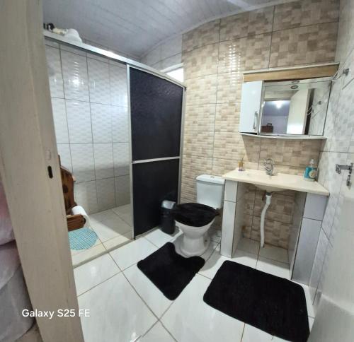 a bathroom with a toilet and a sink and a shower at Bom sossego in Foz do Iguaçu