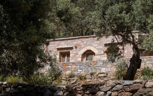 a stone building with a window in a stone wall at Manelis Mills Estate, Guest Houses & Restaurant in Plakias
