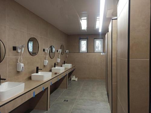 a bathroom with three sinks and a row of mirrors at Happy House Hel in Hel