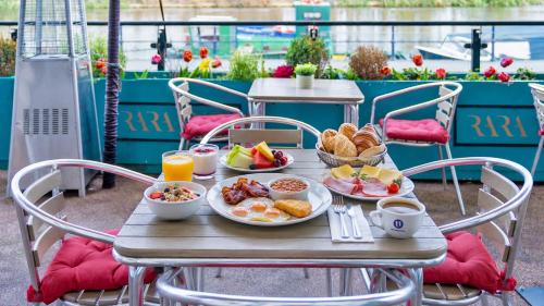 a table with breakfast foods and drinks on it at Uno Thames Hotel -Reopened Brand New Again -FREE PARKING in Maidenhead