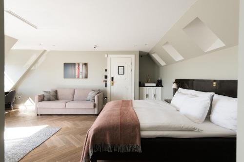 a bedroom with a large bed and a couch at Hotel Skt. Annæ in Copenhagen