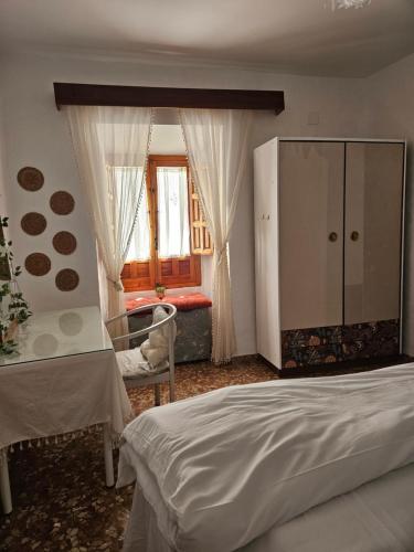 a bedroom with a bed and a cabinet and a window at La Bohème in Antequera