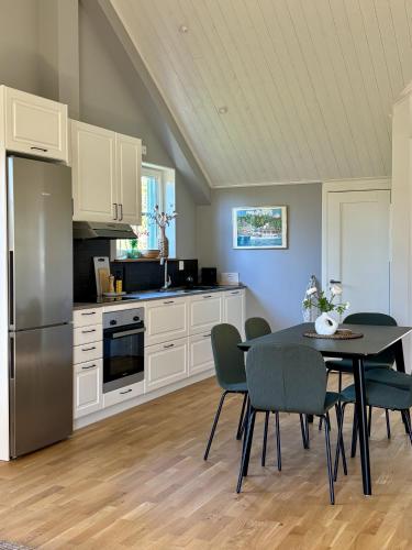 a kitchen with a table and chairs and a refrigerator at Lilla Hotellet Blidö in Blidö