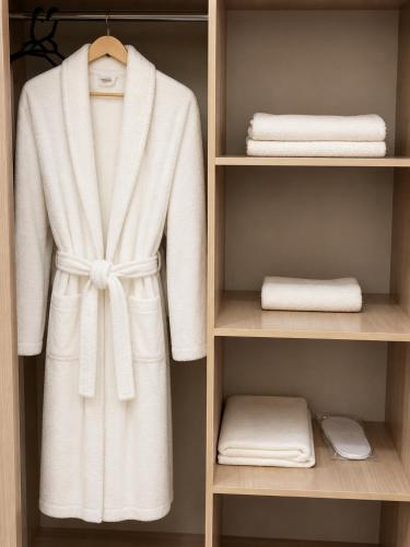 a white robe in a closet with towels at Arena Hotel Tartar in Terter