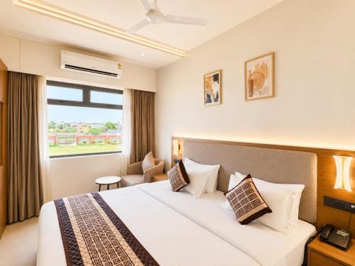 a hotel room with a bed and a window at Avsar Resort in Verāval