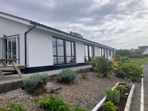 a white house with windows and plants in a yard at Dolphin Watch in Fanore