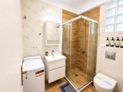 a bathroom with a shower and a toilet and a sink at Pool Access Danai 15,1 in Ofrínion
