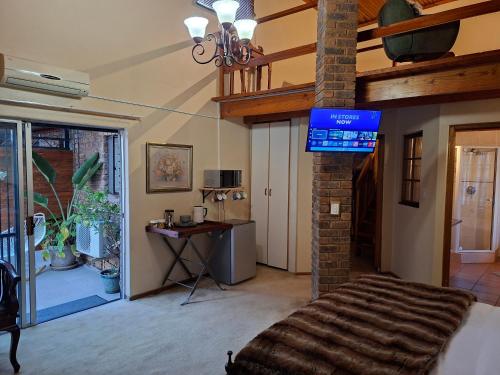 a room with a bed and a tv in a room at De Windmolen in Centurion