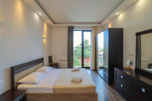 a bedroom with a large bed and a large window at Spacious Sololaki 2BR with Balcony - by Wehost in Tbilisi City