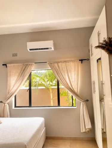 a bedroom with a bed and a window at Wilo Residence in Victoria Falls