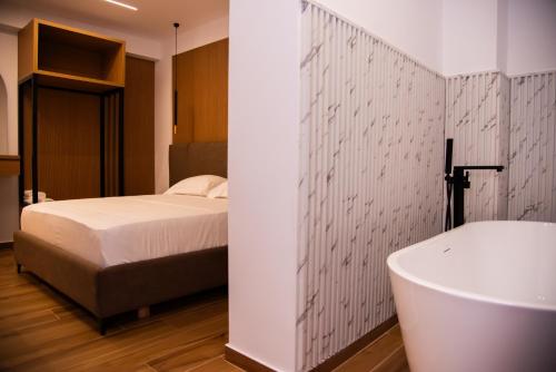 a bedroom with a bed and a bath tub at Dine Residence in Himare