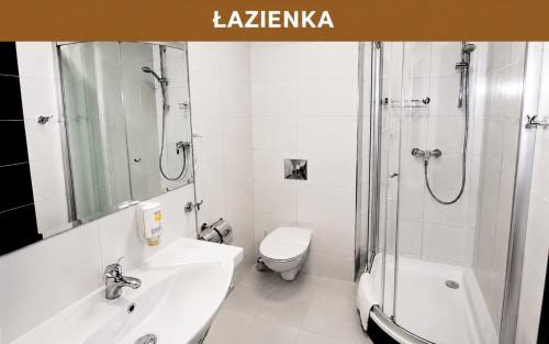 a bathroom with a sink and a toilet and a shower at Hotel Miodowy Młyn in Opatów