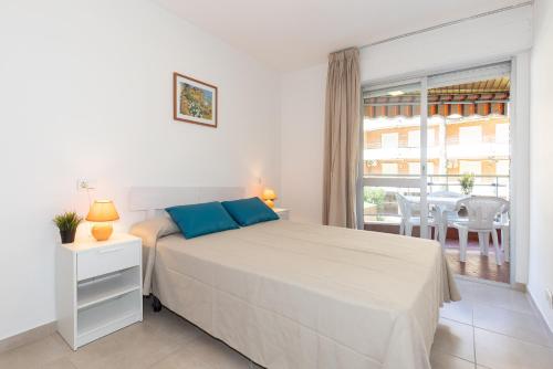 a white bedroom with a bed and a balcony at Rentalmar Sol de España - Mas d'en Gran in Cambrils