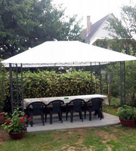 a table and chairs under a white umbrella at Pärlan 1 in Balatonboglár