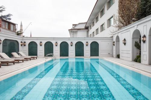 a pool at a hotel with chairs and a building at Sura Concept Hotel in Istanbul