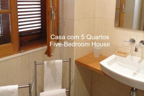 a bathroom with a sink and a toilet and a mirror at First Balcony - Porto Santo in Porto Santo