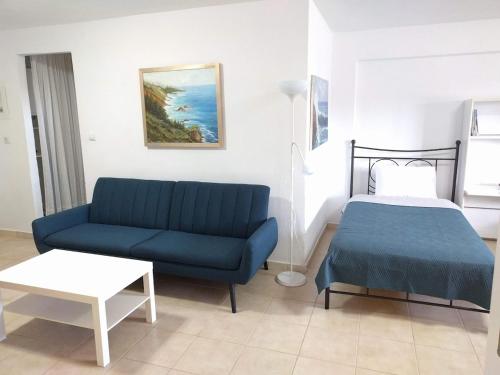 a living room with a blue couch and a bed at Almond Apartments Ground Floor Apt in Ofrínion