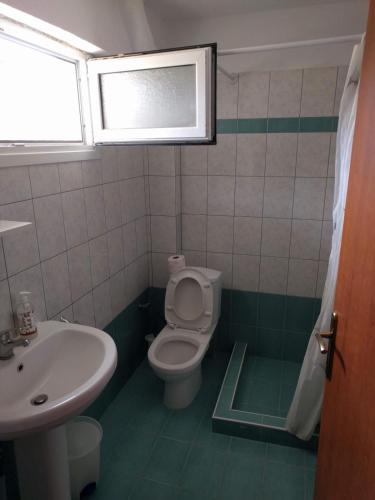 a bathroom with a toilet and a sink at Almond Apartments Ground Floor Apt in Ofrínion