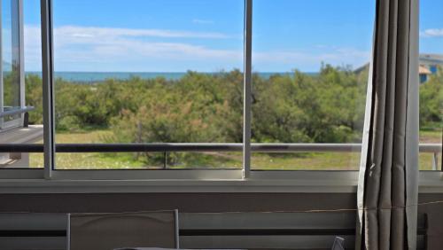 a room with a window with a view of the ocean at La Rose des Sables - face à la mer in Frontignan