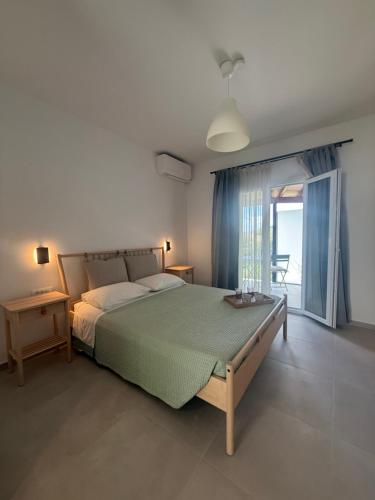 a bedroom with a large bed and a large window at Sofia Studios in Benitses