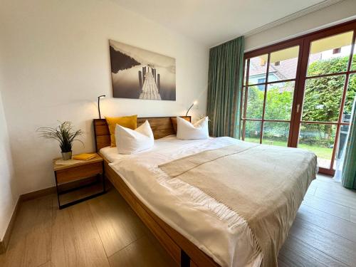 a bedroom with a large bed and a large window at Oewern Diek App 02 in Wustrow