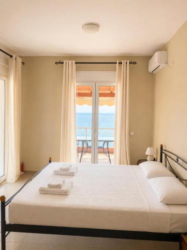 a bedroom with a bed with a view of the ocean at PNOÉ rooms in Ilia